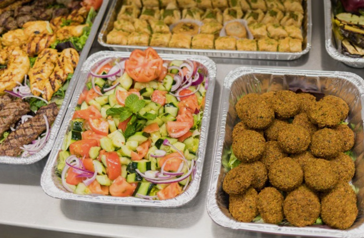 Shawarma West corporate catering spread with falafel, chopped salad, grilled meats, vegetables and baklava